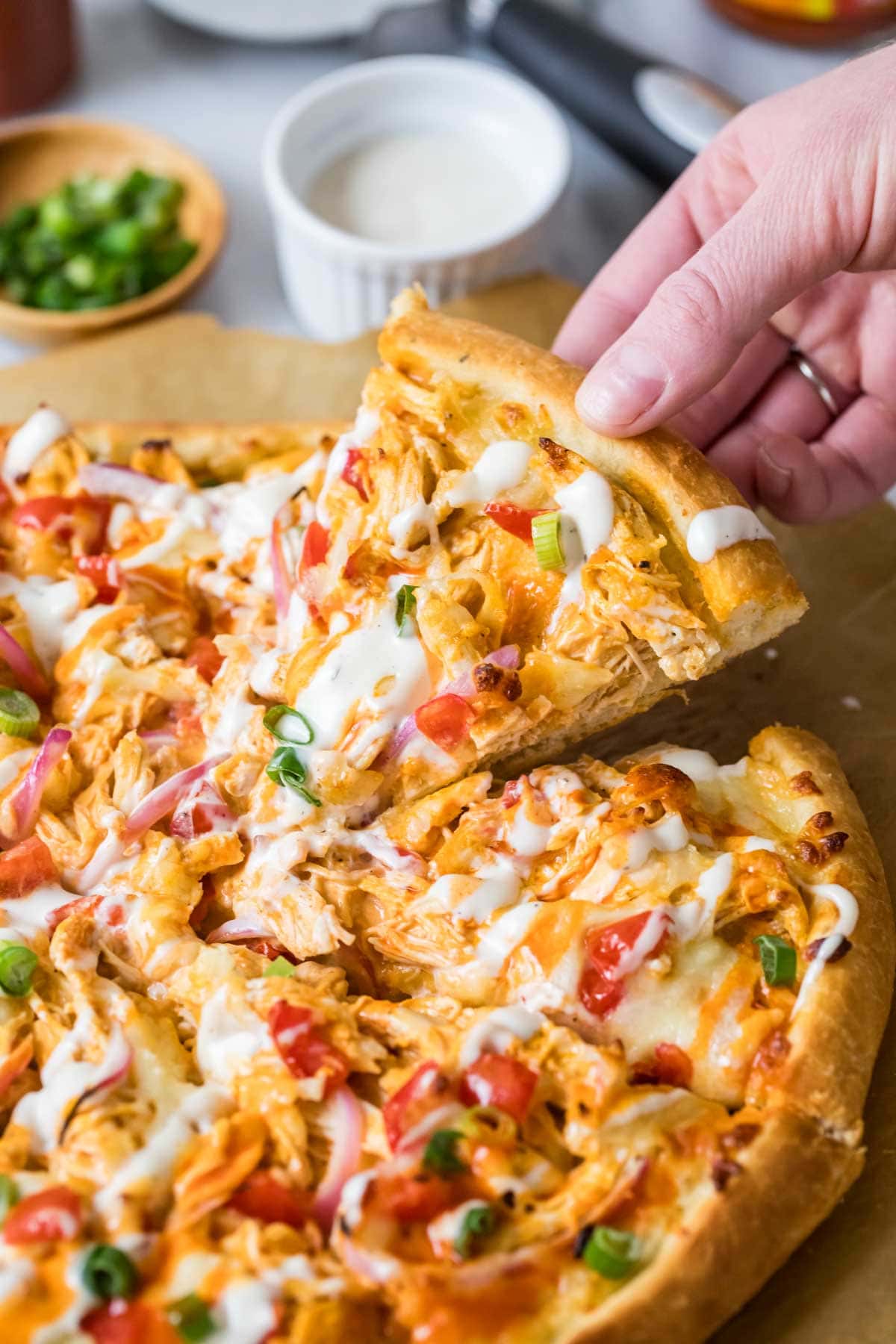Slice being pulled from a pizza made with buffalo chicken.