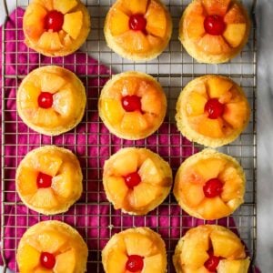 Overhead view of pineapple upside down cupcakes on a cooling rack.