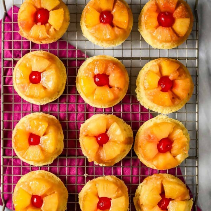 Overhead view of pineapple upside down cupcakes on a cooling rack.