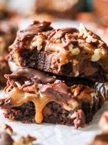 Two turtle brownies stacked on top of each other with the top brownie missing a bite.