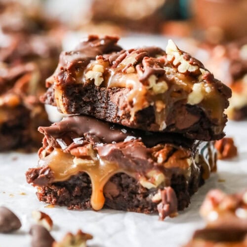 Two turtle brownies stacked on top of each other with the top brownie missing a bite.