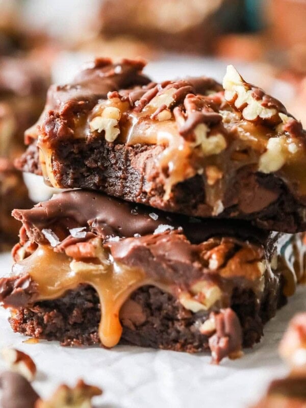 Two turtle brownies stacked on top of each other with the top brownie missing a bite.