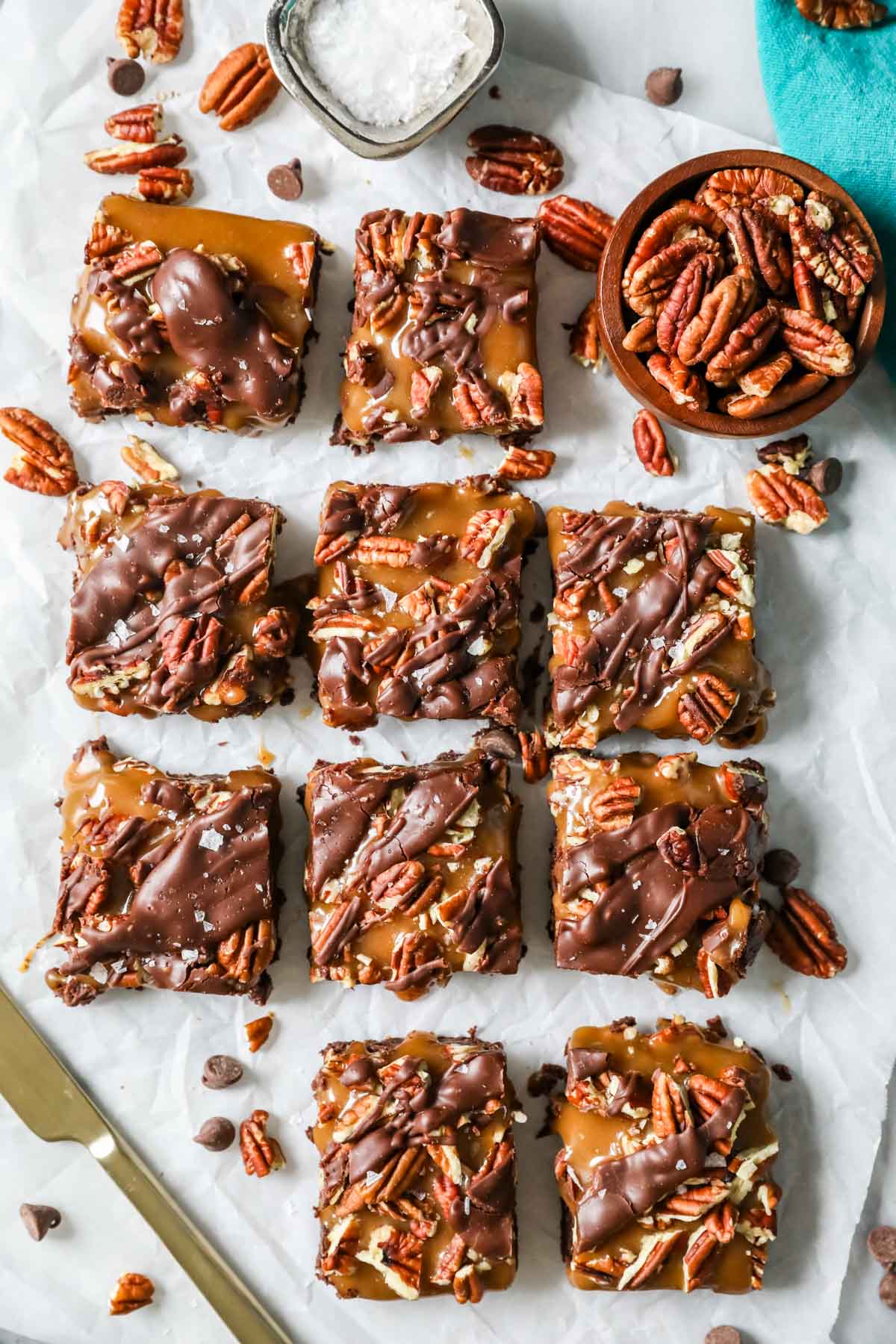 Overhead view of brownies topped with caramel and pecans.