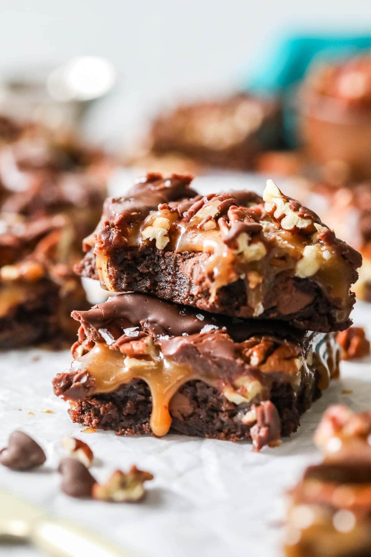 Two turtle brownies stacked on top of each other with the top brownie missing a bite.