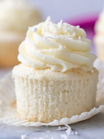 White cupcake that's been unwrapped to show a snow white crumb.