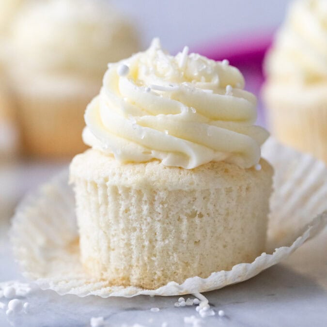 White cupcake that's been unwrapped to show a snow white crumb.