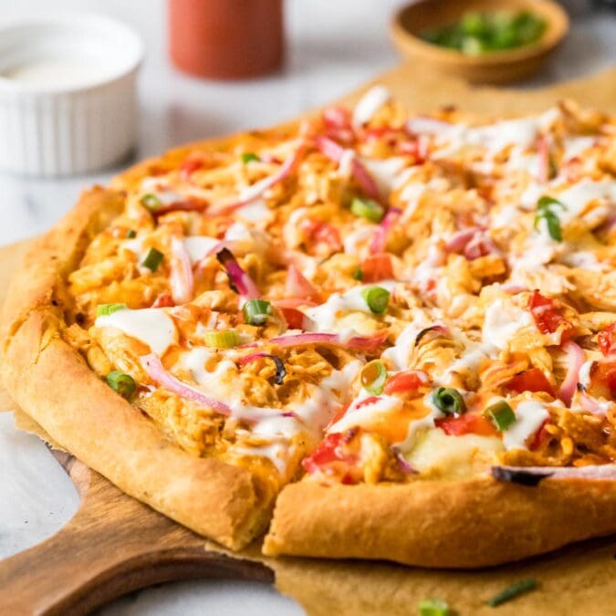 Homemade buffalo chicken on a wood serving platter.