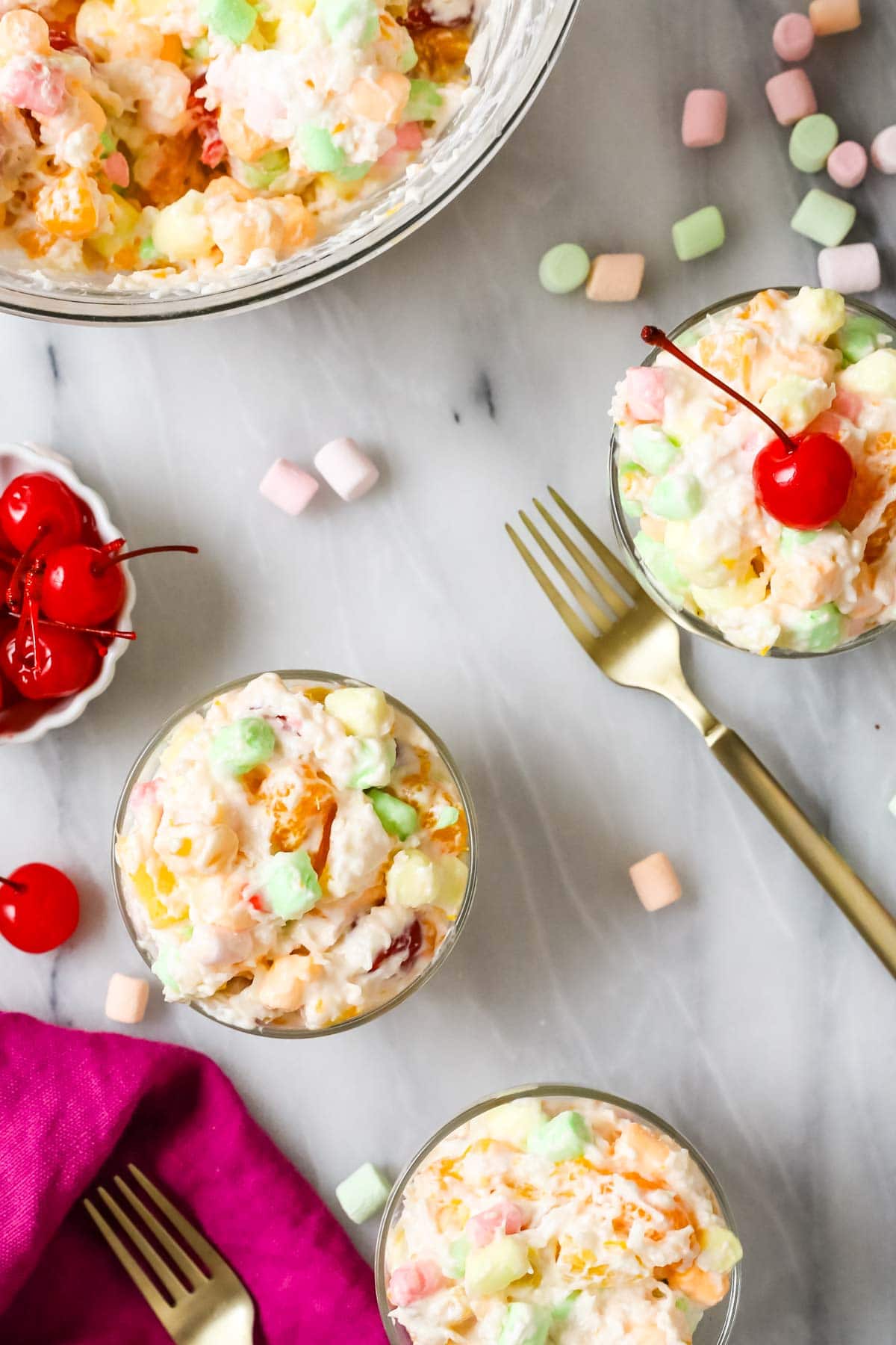 Overhead view of bowls of a fruit and marshmallow salad made with homemade whipped cream.