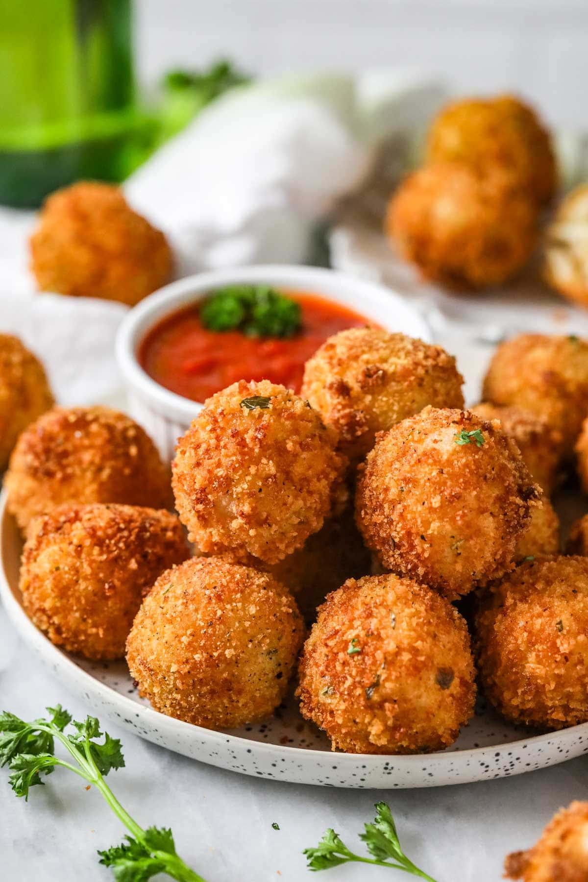 Bowl of Sicilian fried rice balls with marinara for dipping.