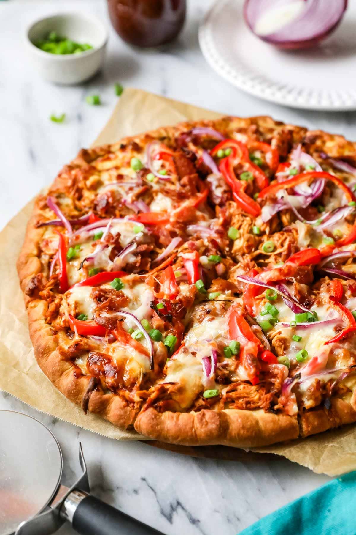 BBQ chicken pizza topped with red onion, bell pepper, and more.
