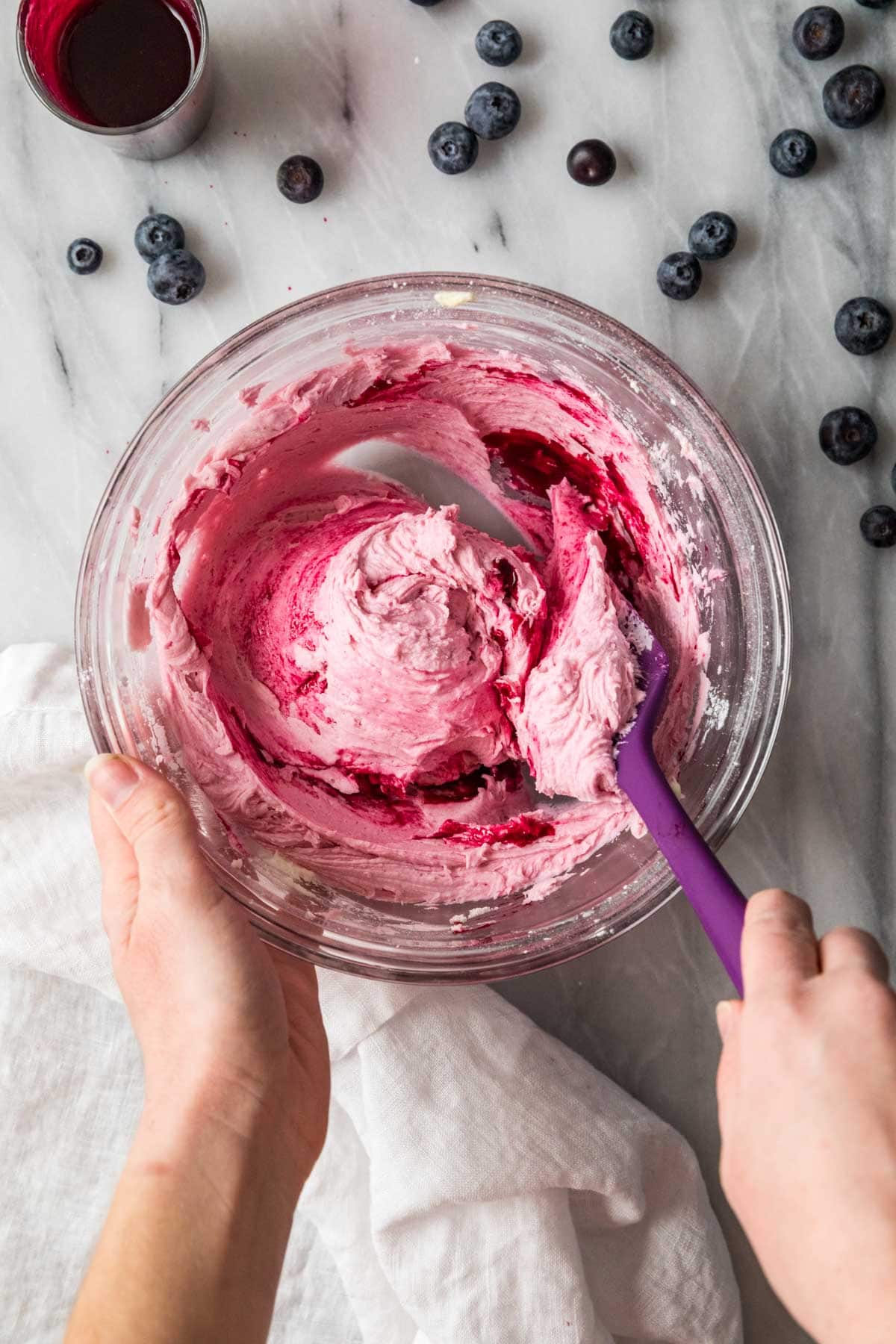 Blueberry sauce being folded into butter and sugar to make a blueberry buttercream.