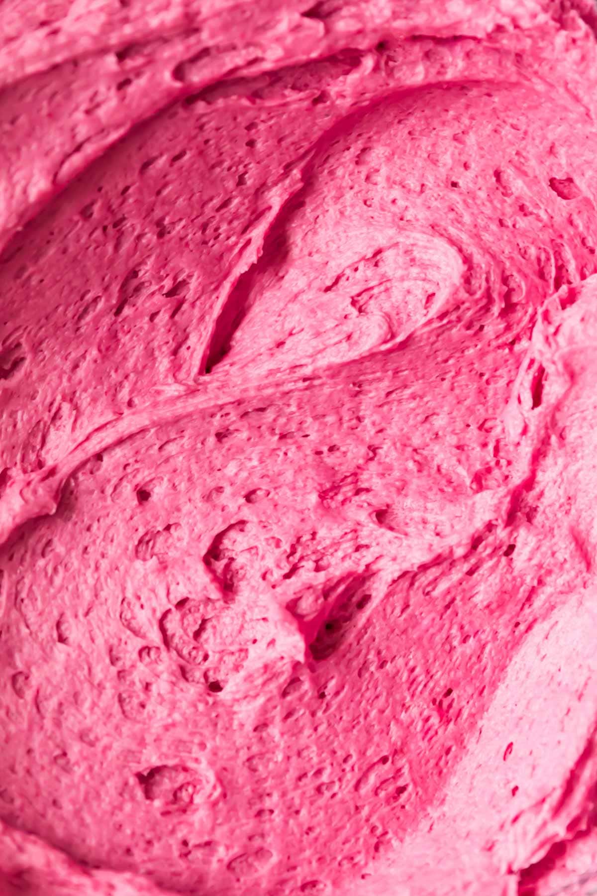 Close-up view of a vibrant pink frosting made from fresh blueberries.