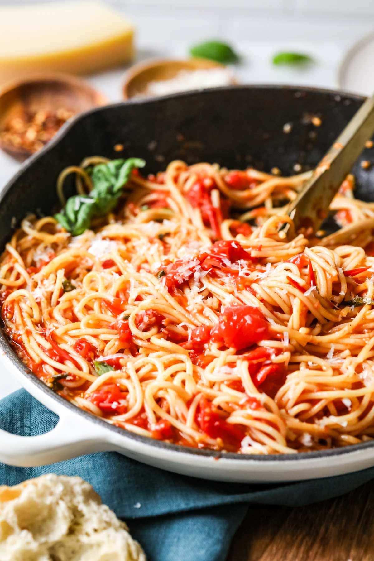 Skillet of spaghetti tossed with a sauce made from cherry tomatoes.