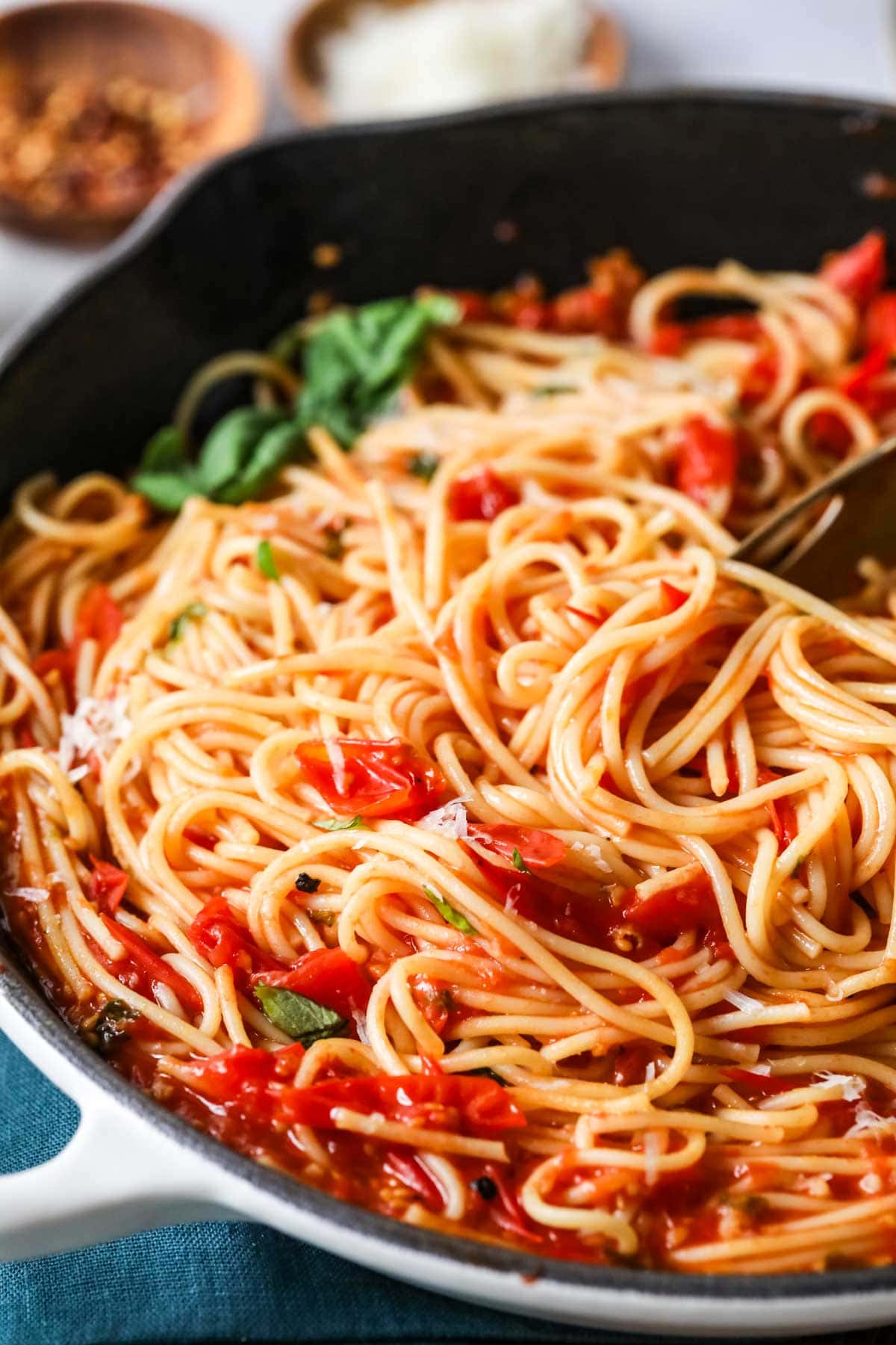 Close-up view of spaghetti tossed with a cherry tomato sauce.