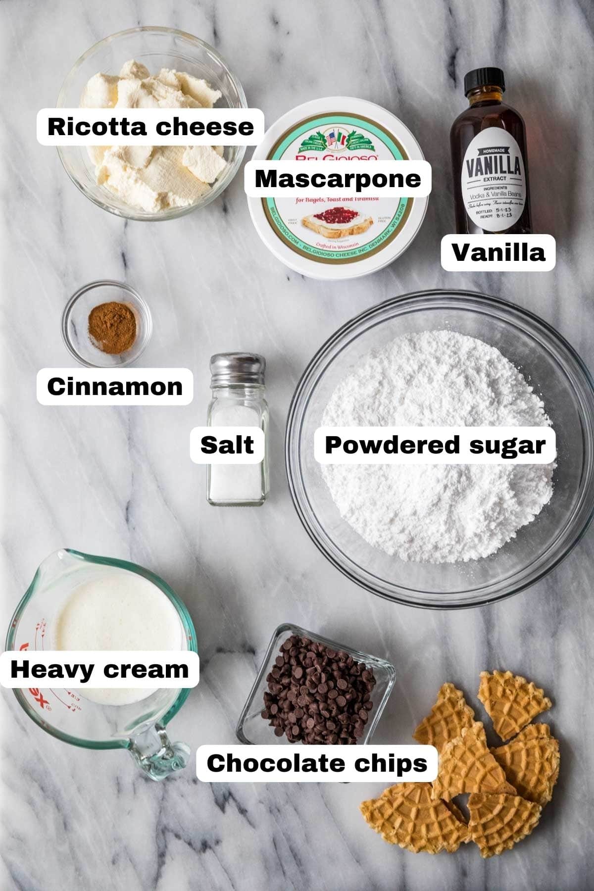 Overhead view of labelled ingredients including ricotta, mascarpone, cinnamon, and more.