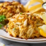 Close-up view of golden brown, Maryland-style crab cakes on a plate.