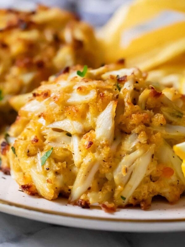Close-up view of golden brown, Maryland-style crab cakes on a plate.