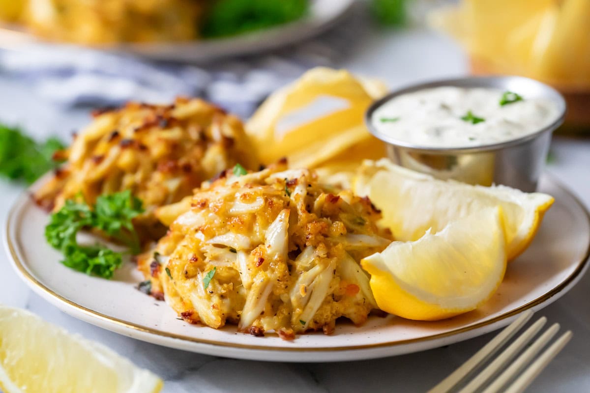 Close-up view of golden brown, Maryland-style crab cakes on a plate.