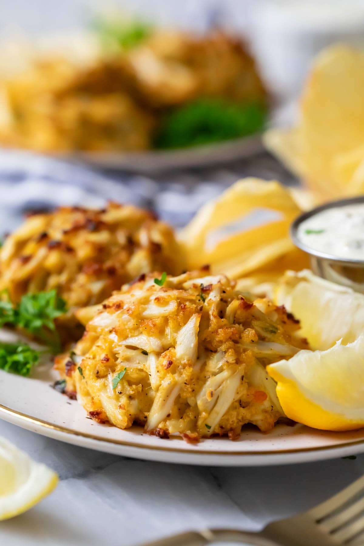 Close-up view of golden brown, Maryland-style crab cakes on a plate.