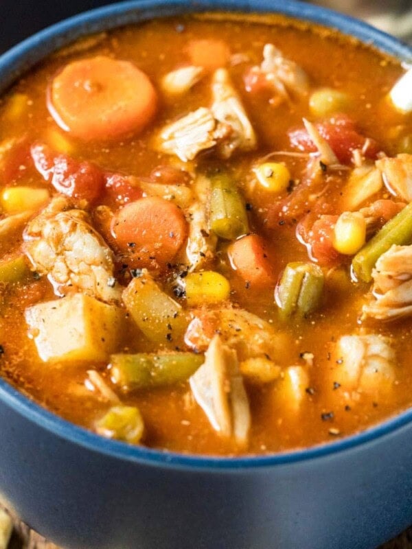 Blue bowl of maryland crab soup made with a tomato base, lump crab meat, old bay, and more.
