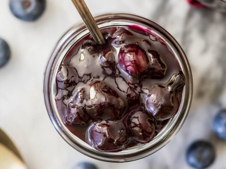 Overhead view of a jar of blueberry sauce.