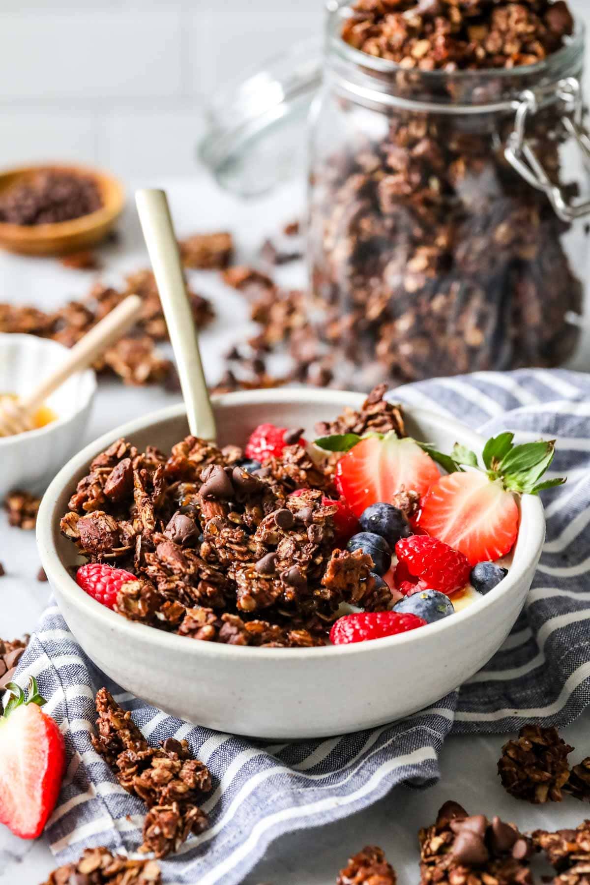 Bowl of yogurt and berries topped with a cocoa based granola.