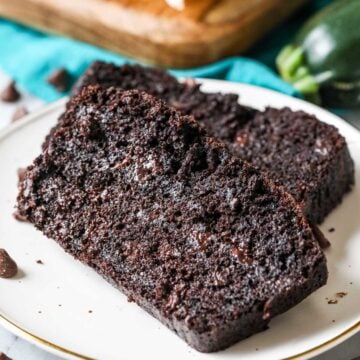 Two slices of chocolate zucchini bread on a plate.