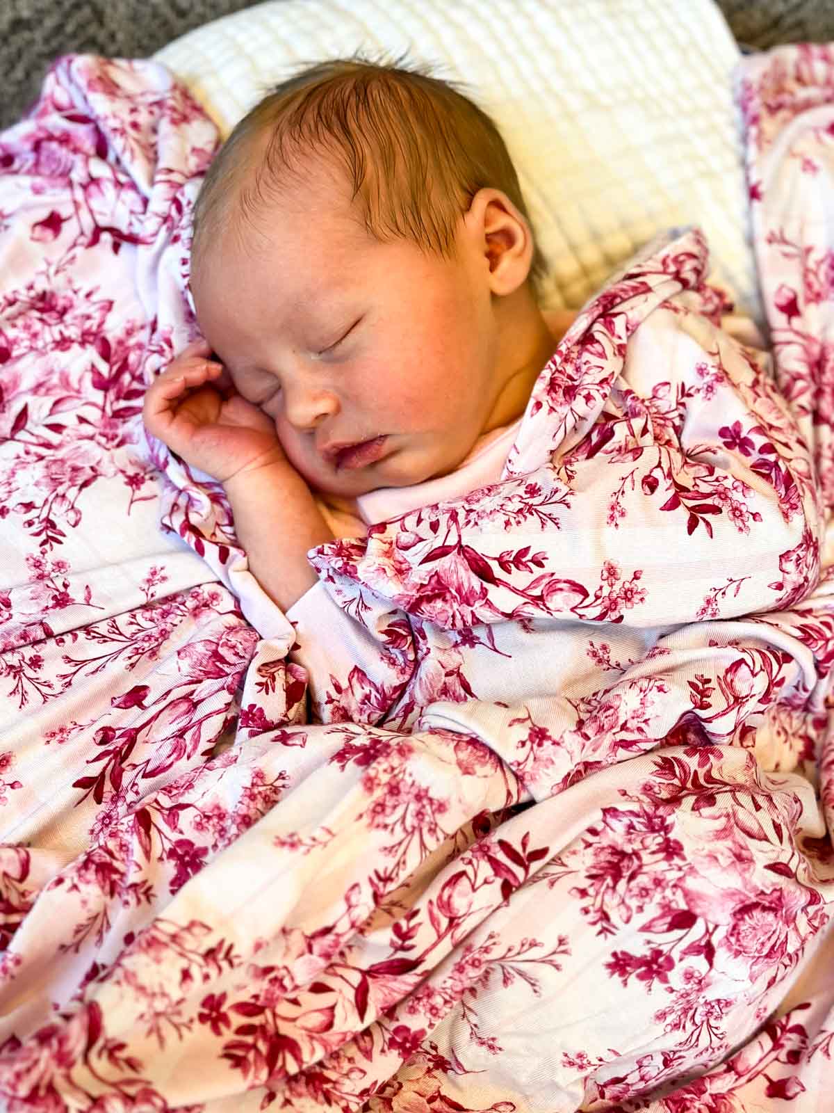 Sleeping baby with pink floral blanket