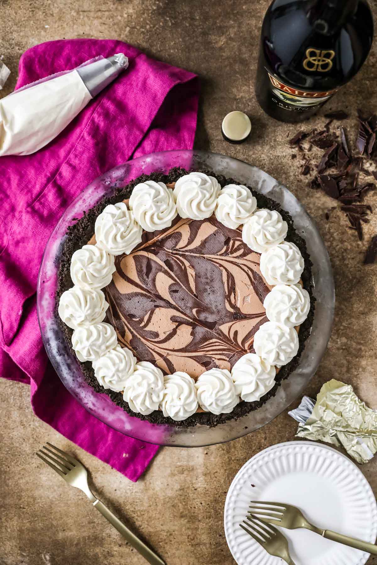 Overhead view of a frozen mudslide pie with a swirled chocolate top and whipped cream border.