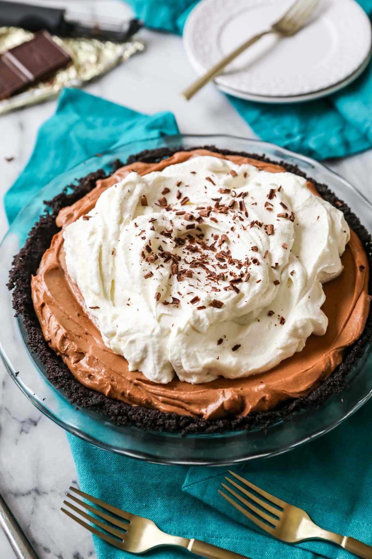 Mississippi mud pie topped with a thick layer of whipped cream and chocolate shavings.