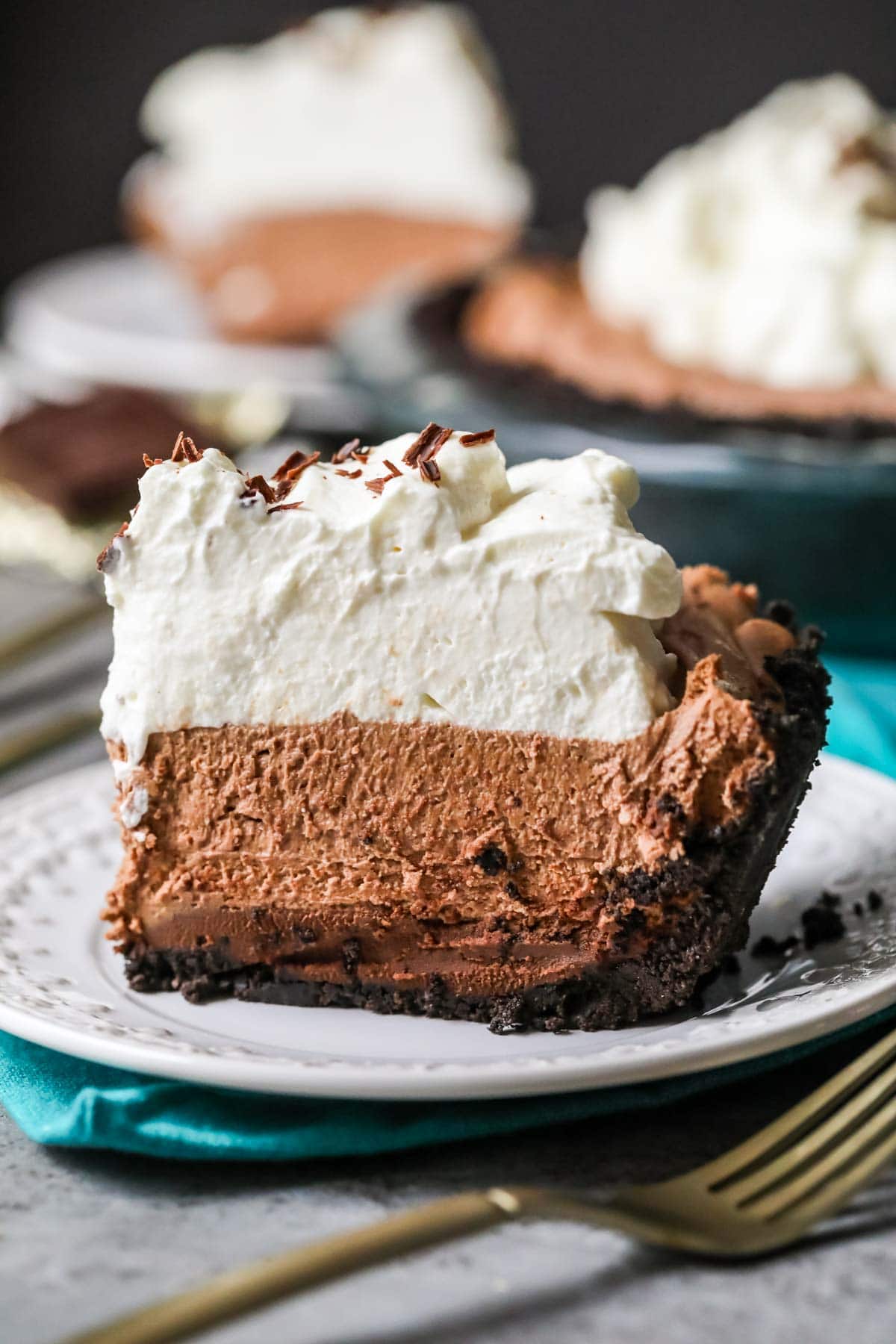 Slice of mississippi mud pie topped with a thick layer of whipped cream.