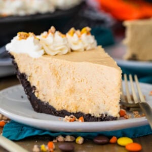 Slice of peanut butter pie with an Oreo crust on a plate.