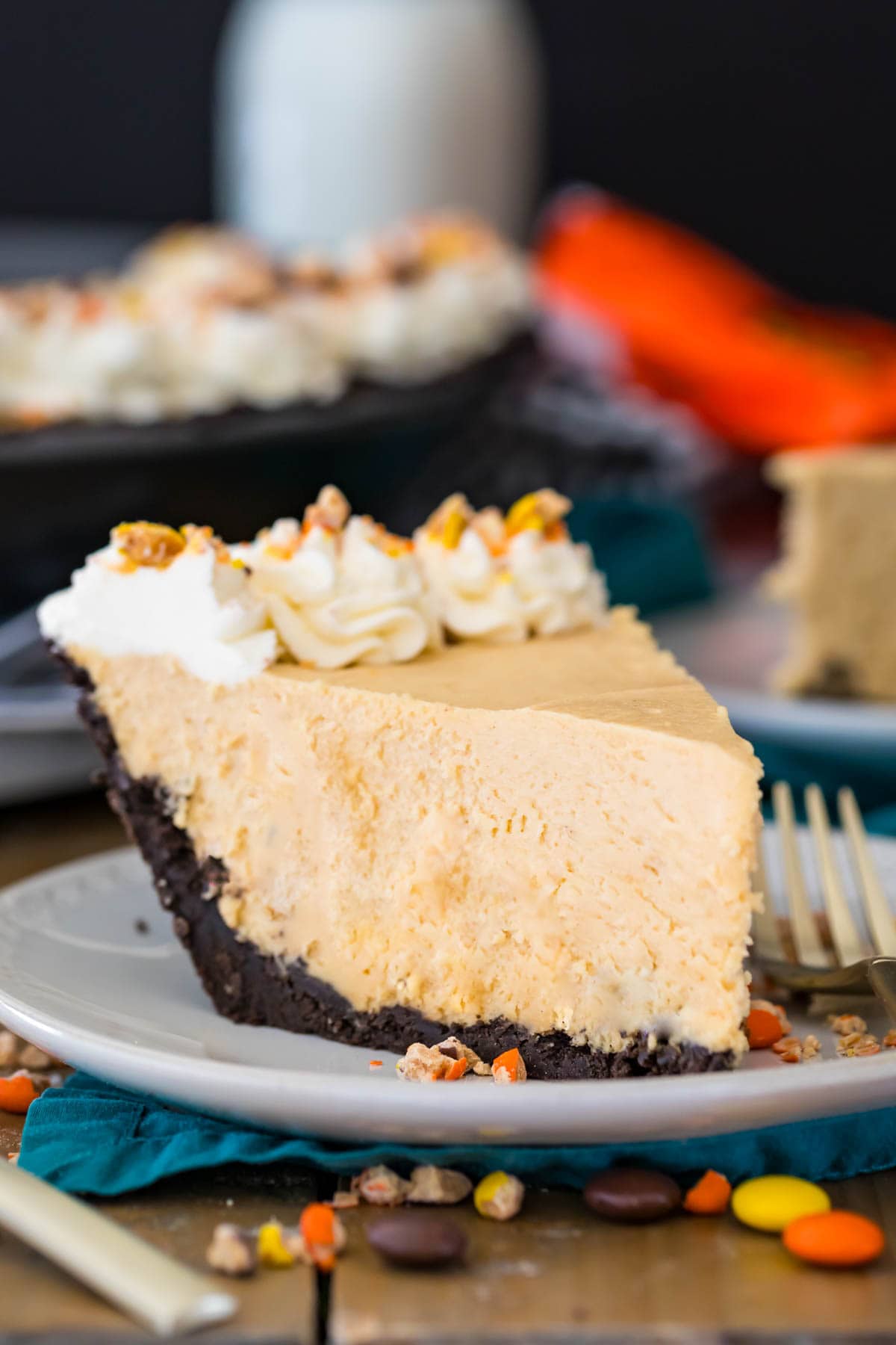 Slice of peanut butter pie with an Oreo crust on a plate. 