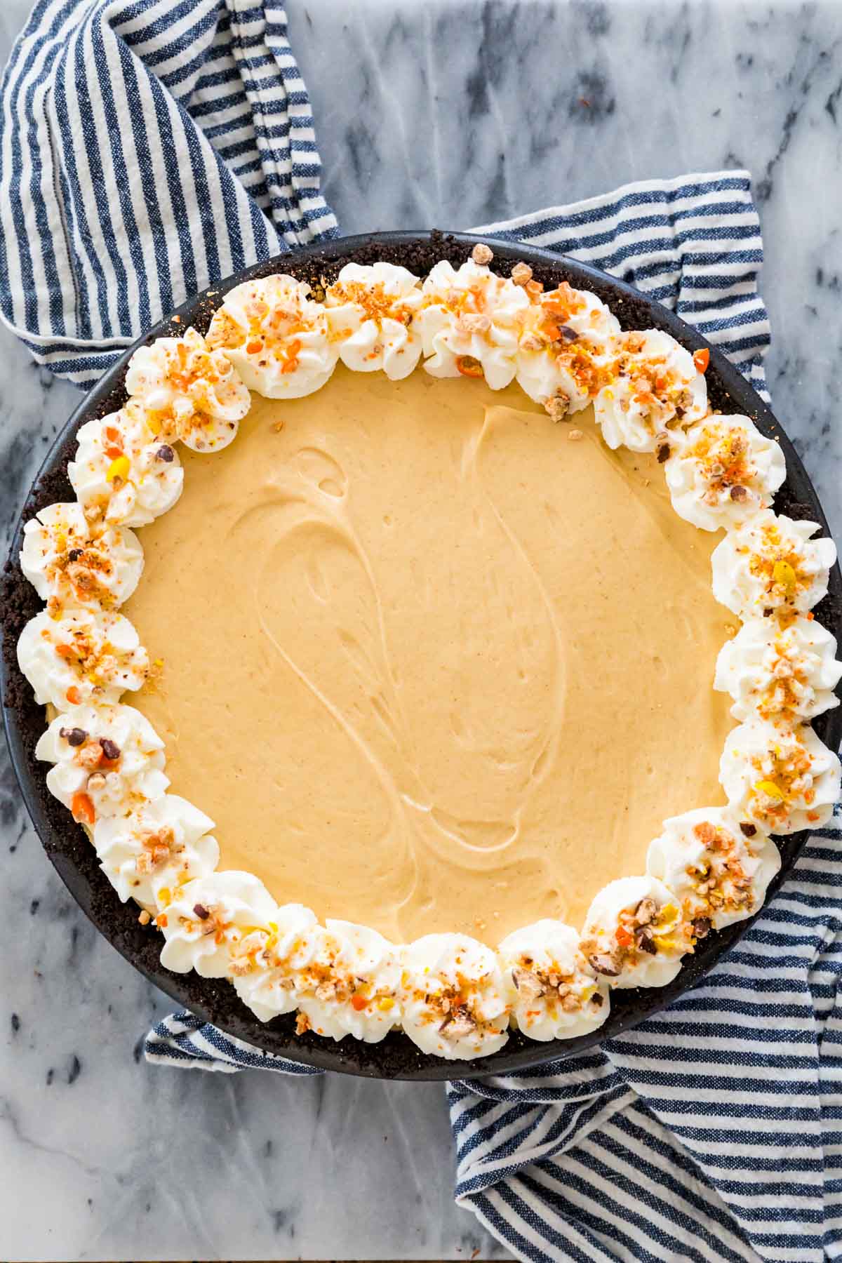 Overhead view of a no-bake pie made with a peanut butter filling and an Oreo crust.