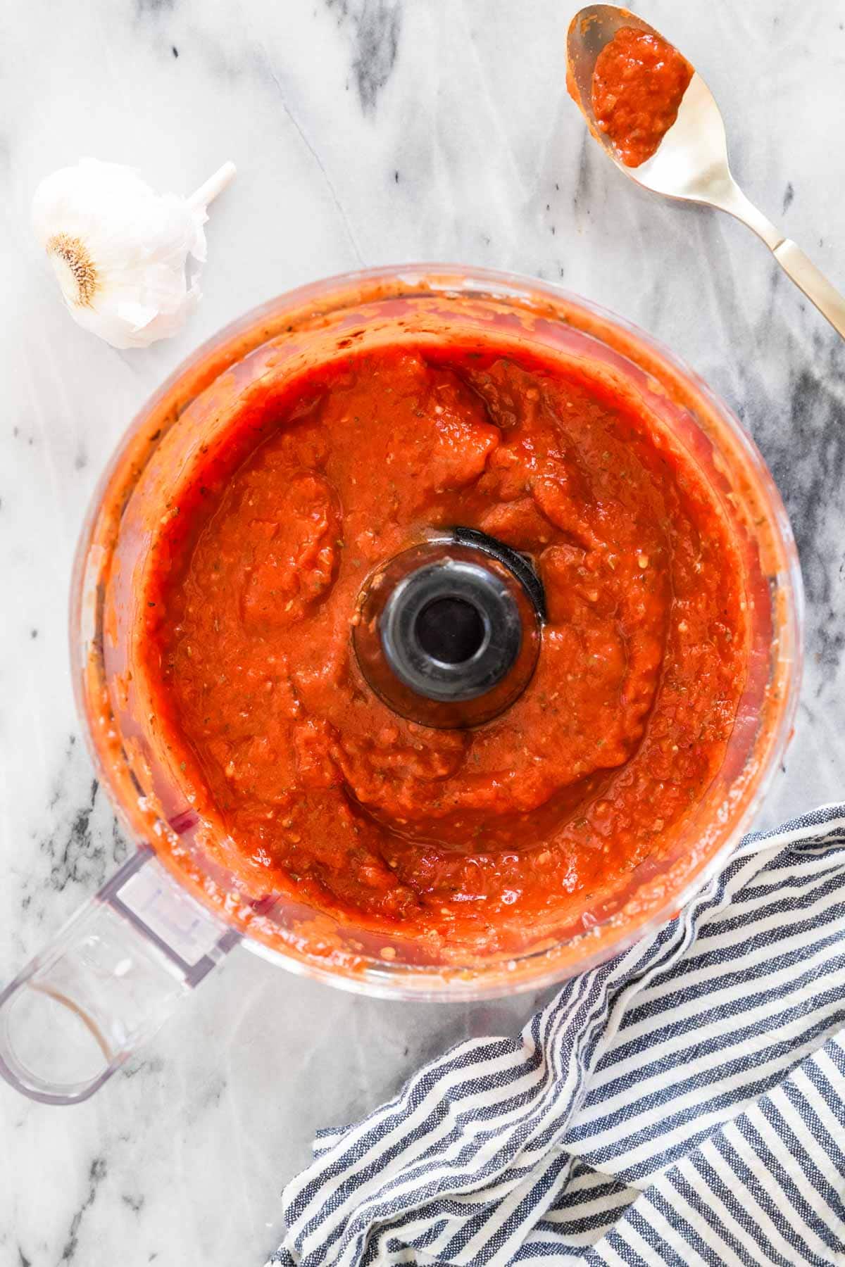 Overhead view of homemade pizza sauce in a food processor.