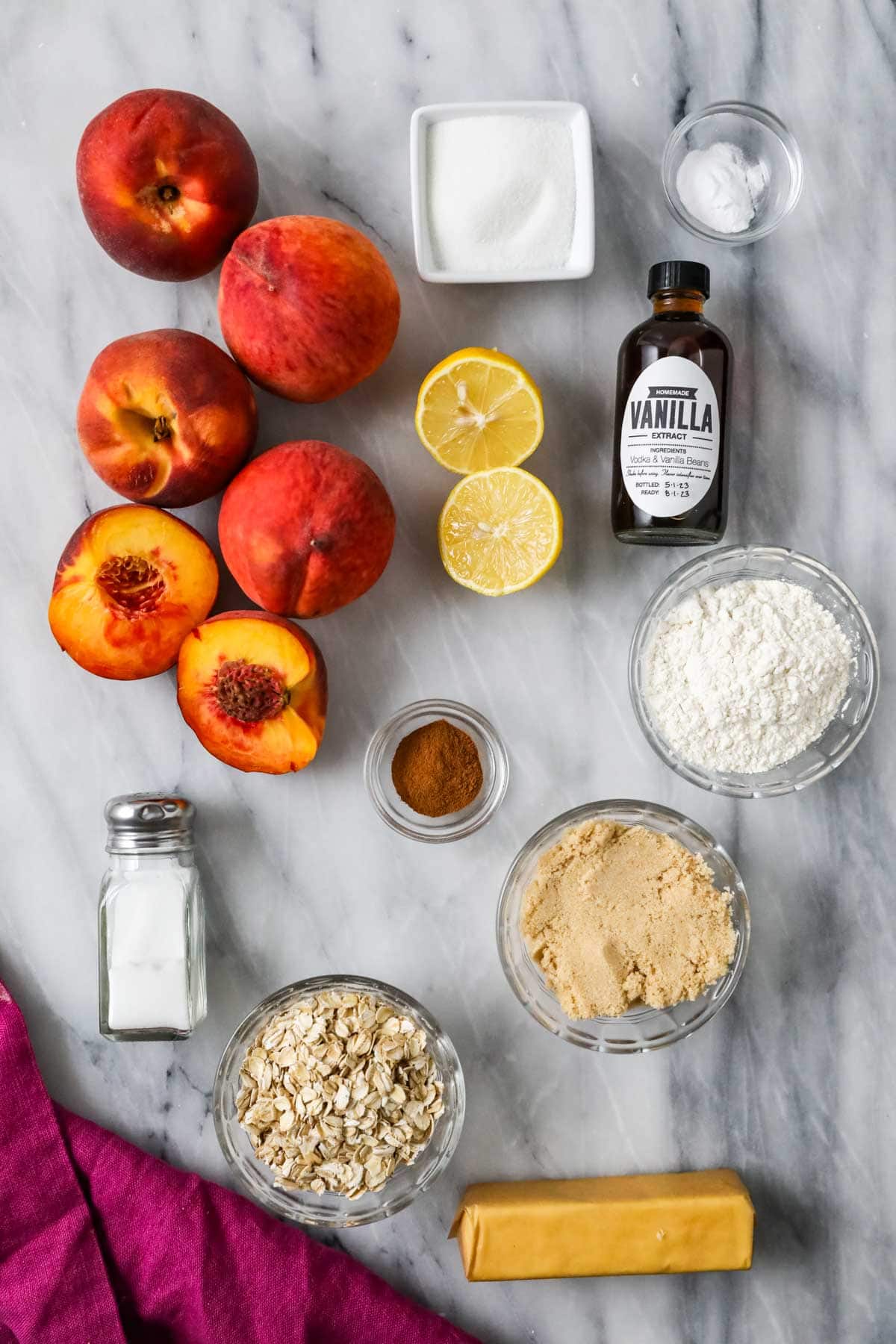 Overhead view of ingredients including peaches, oats, butter, and more.