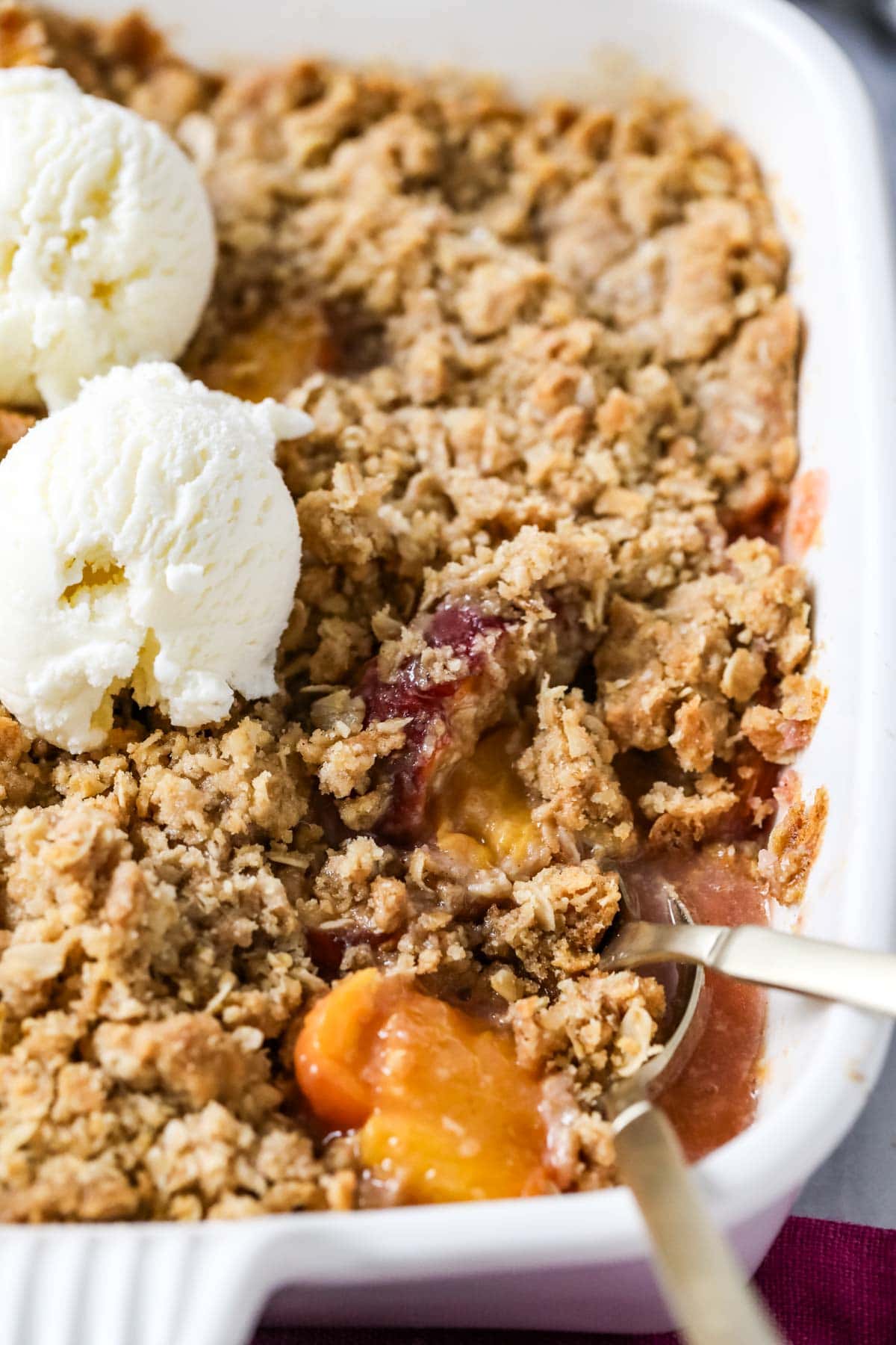 Close-up view of peach crisp in a casserole dish.