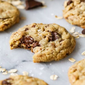 Close-up view of a brown butter oatmeal chocolate chip cookie with a bite missing.