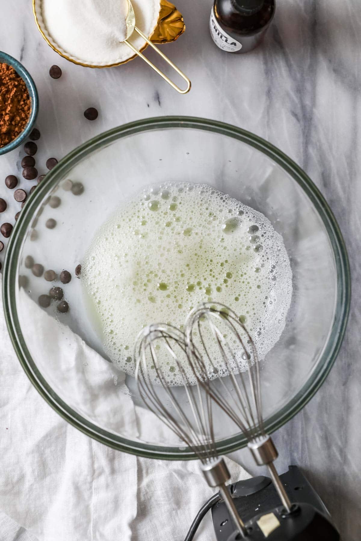 Overhead view of a bowl of foamy egg whites.