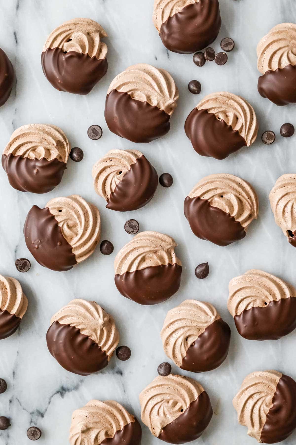 Overhead view of chocolate meringue cookies that have been dipped in chocolate.