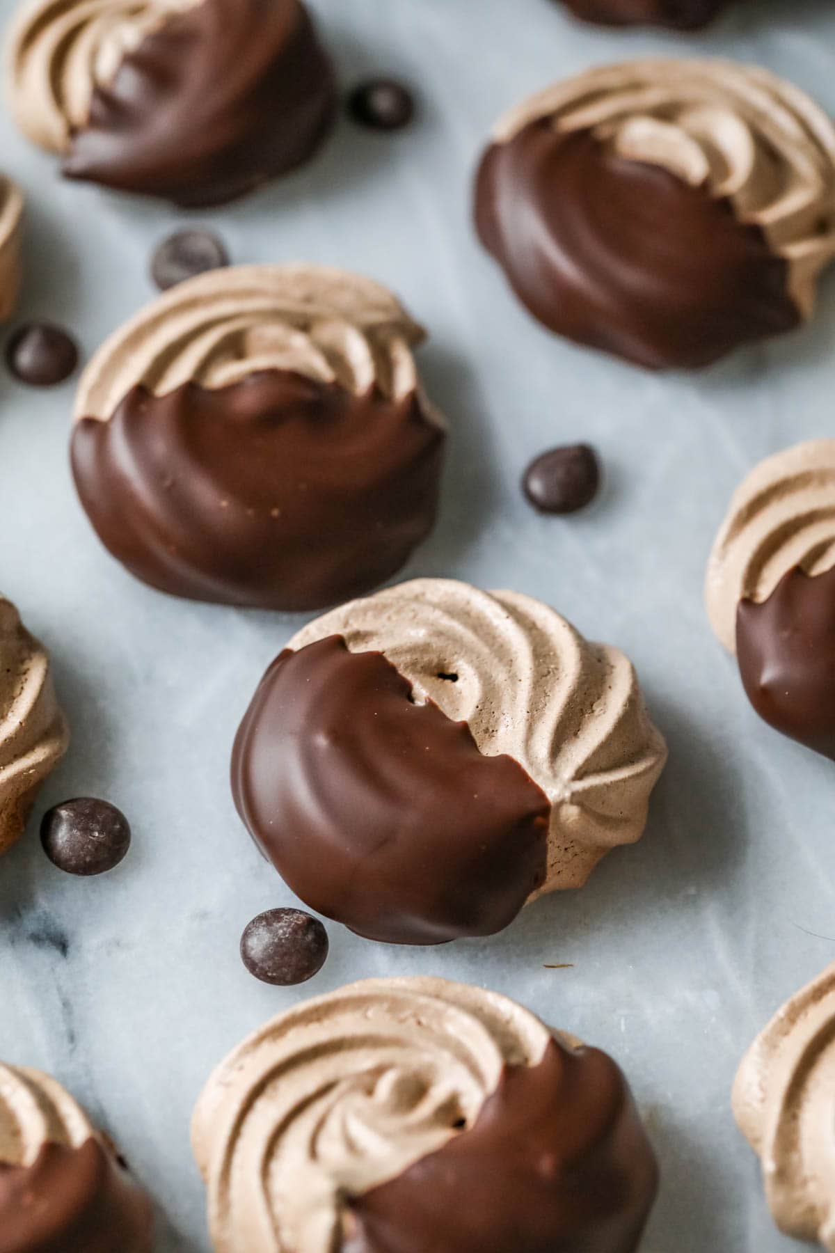 Close-up view of chocolate meringue cookies that have been dipped in chocolate.