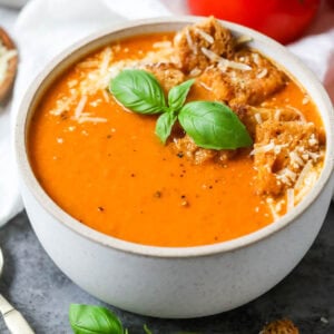 Overhead view of a bowl of tomato basil soup made with fresh tomatoes and basil.