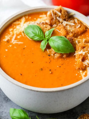 Overhead view of a bowl of tomato basil soup made with fresh tomatoes and basil.