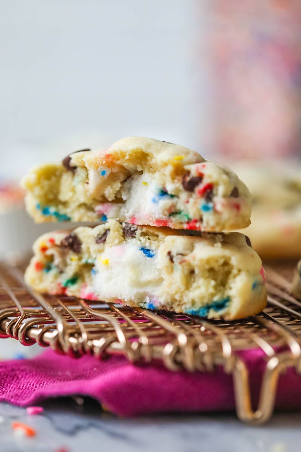 Two halves of a frosting filled chocolate chip cookie stacked on top of each other.