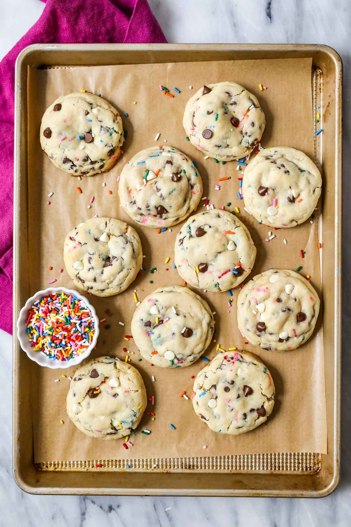 Overhead view of thick cookies topped with chocolate chips and sprinkles.