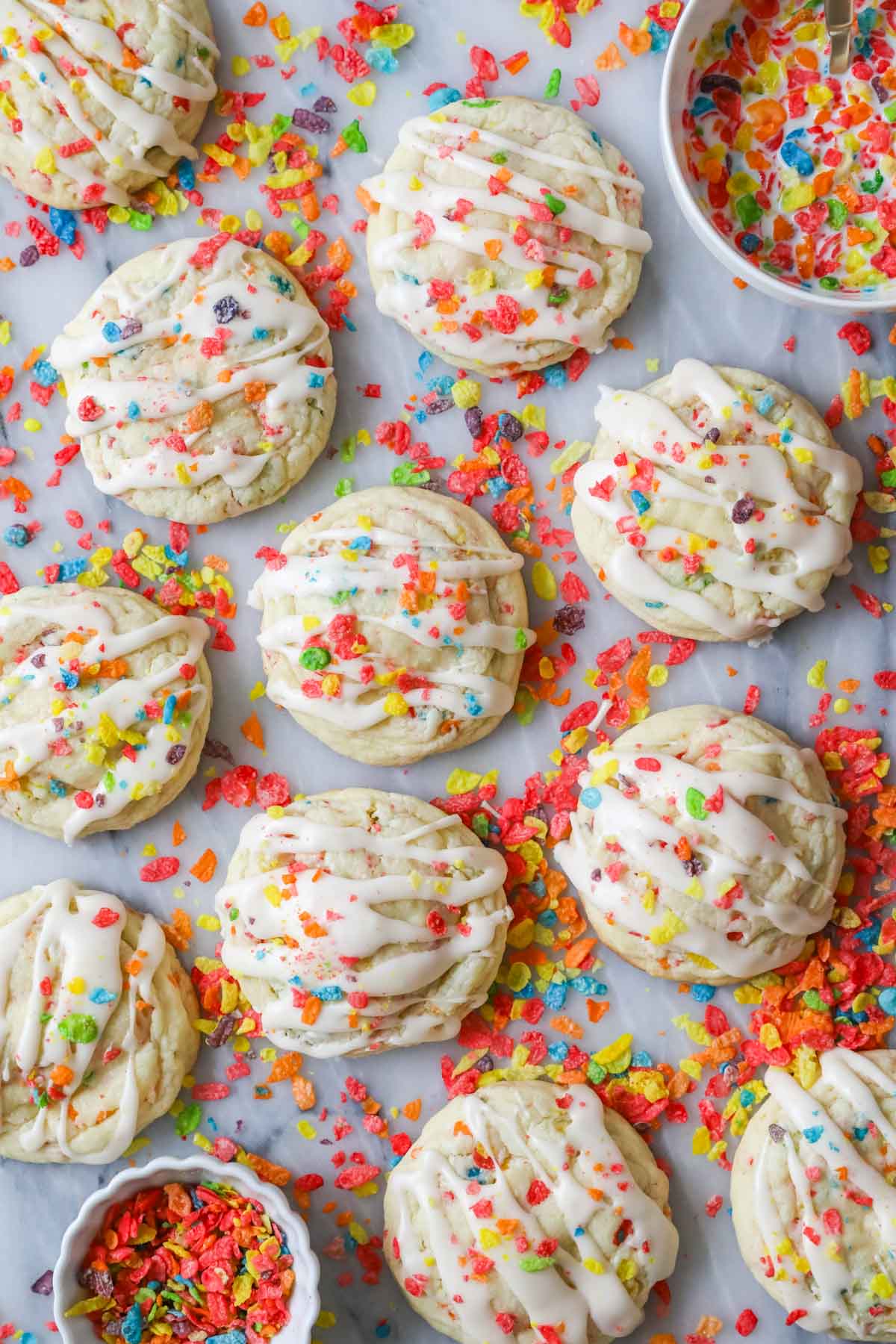 Overhead view of Fruity Pebbles cookies with cereal scattered around them.