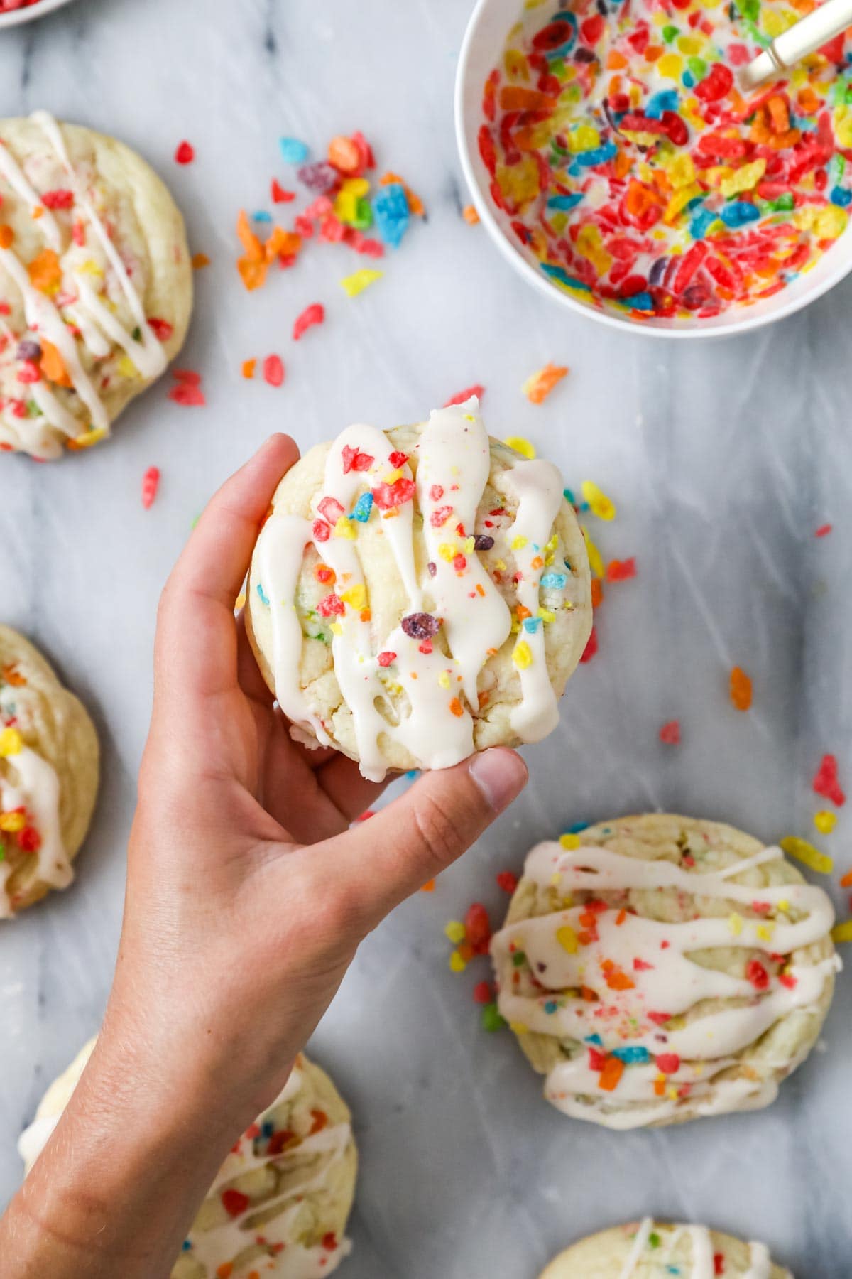 Hand holding a Fruity Pebbles cookie.