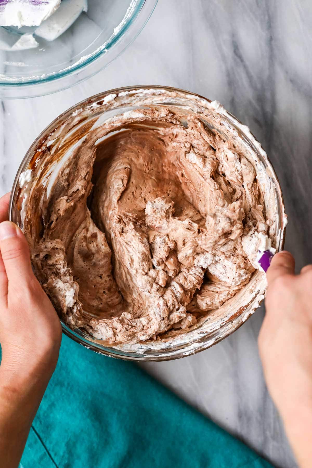 Overhead view of a chocolate and whipped cream mixture that's being folded together.