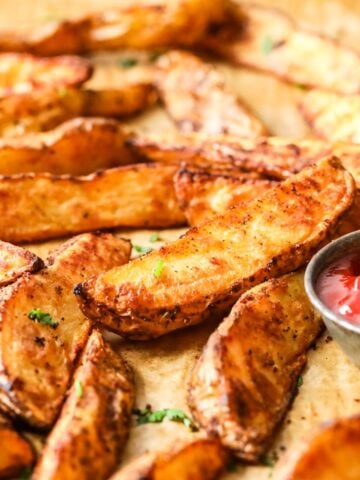 Close-up view of potato wedges on a baking tray.