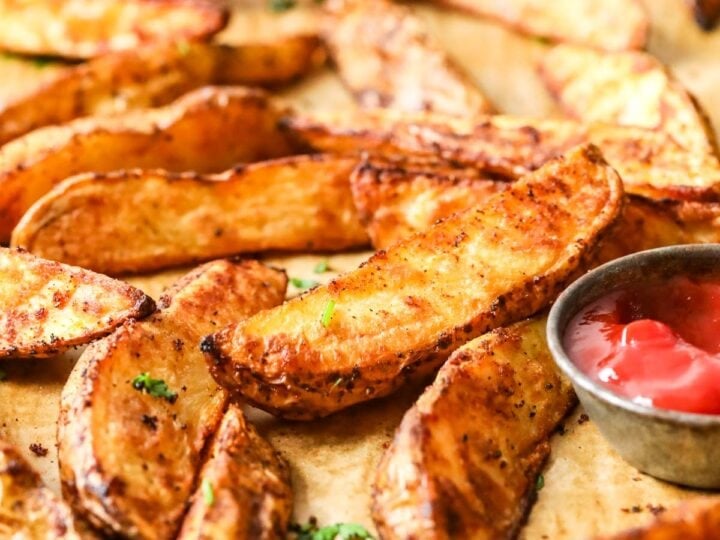 Close-up view of potato wedges on a baking tray.